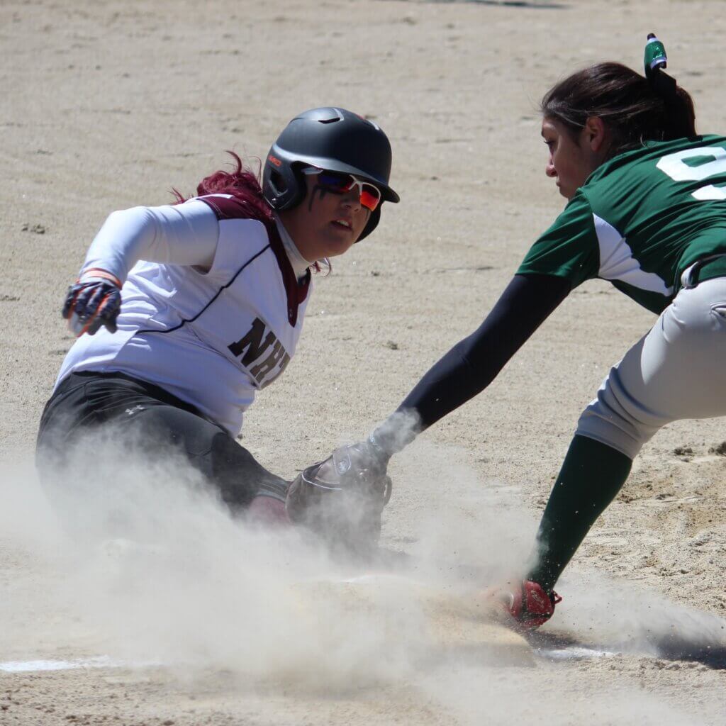 NHTI Women's Softball sliding into base