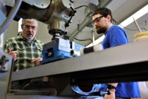 Professor Jeff Beltramo instructs a student on how to use equipment in the engineering programs lab
