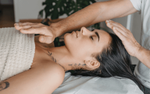Woman has reiki performed on her, as part of the Business Training Center course.