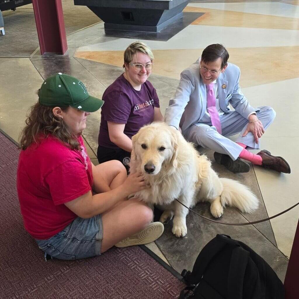 President Tompkins with students and therapy dogs