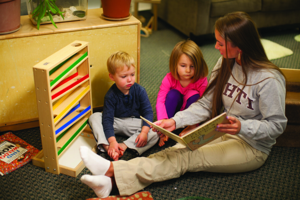 NHTI student reading to toddlers