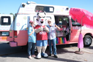 Leroy the Lynx mascot poses outside a food truck