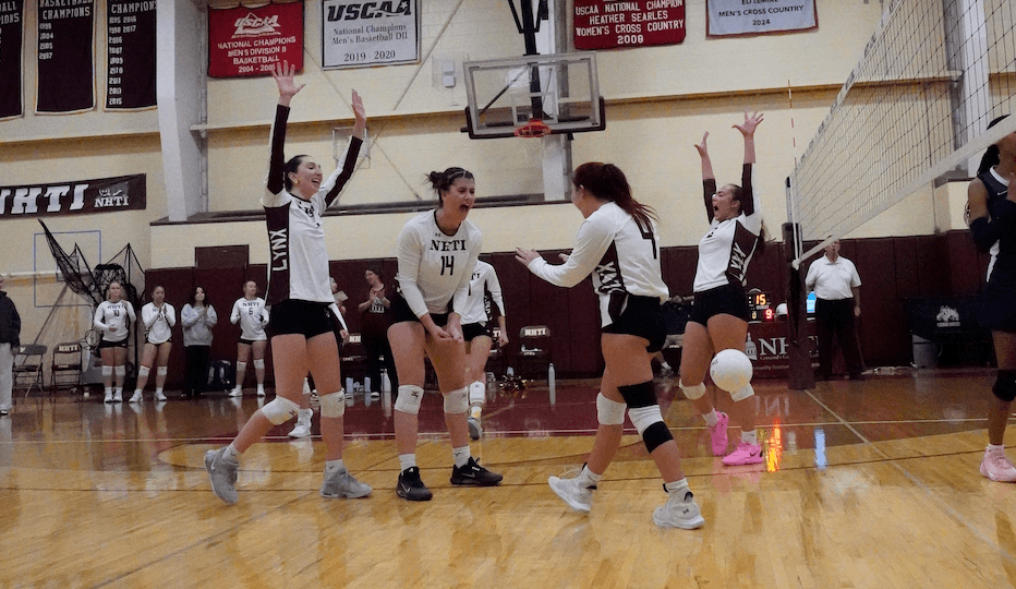 NHTI volleyball team cheers after a win