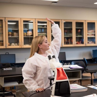 Science student raising hand in class